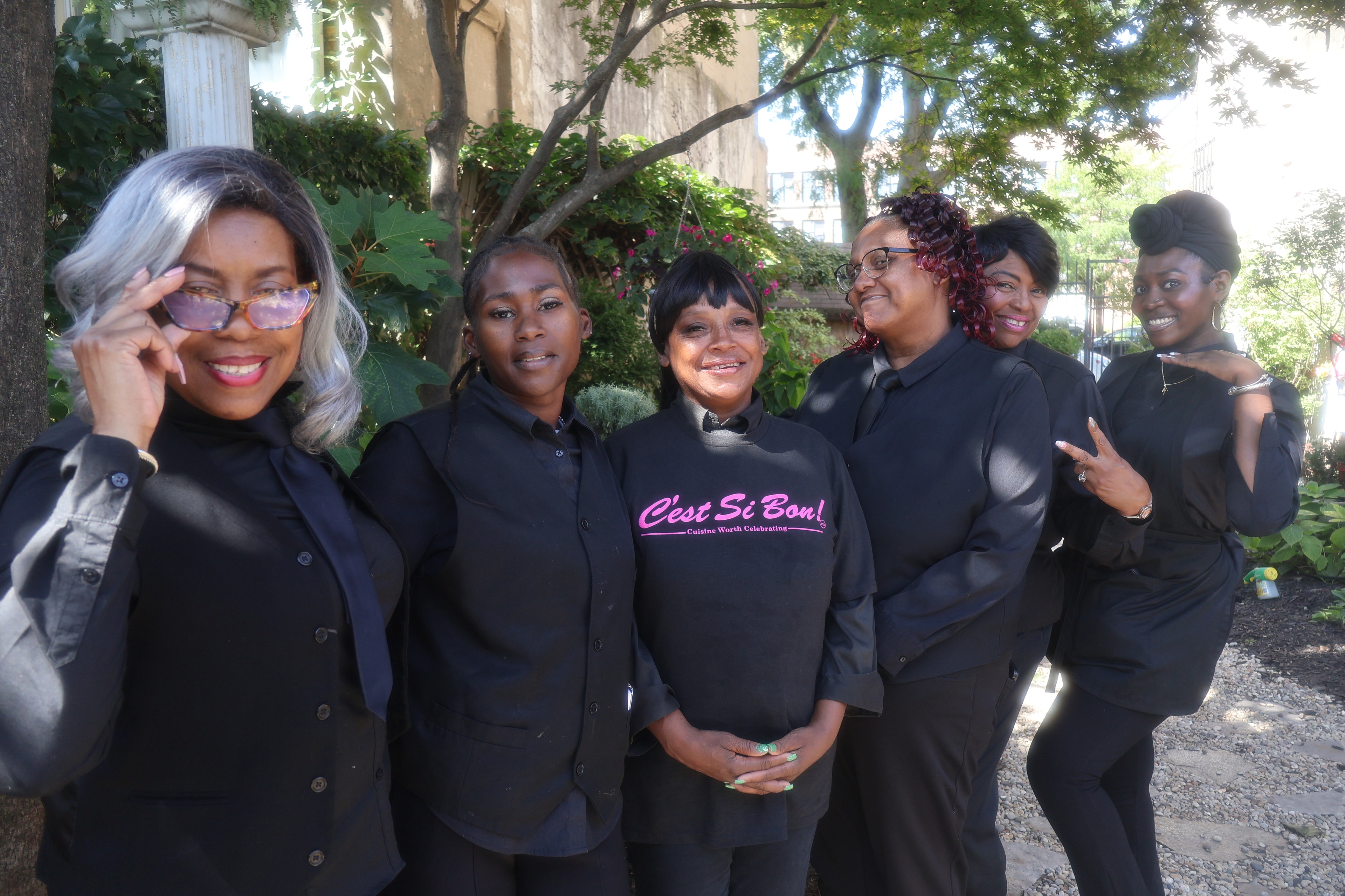 C'est Si Bon team of six in black uniforms outdoors