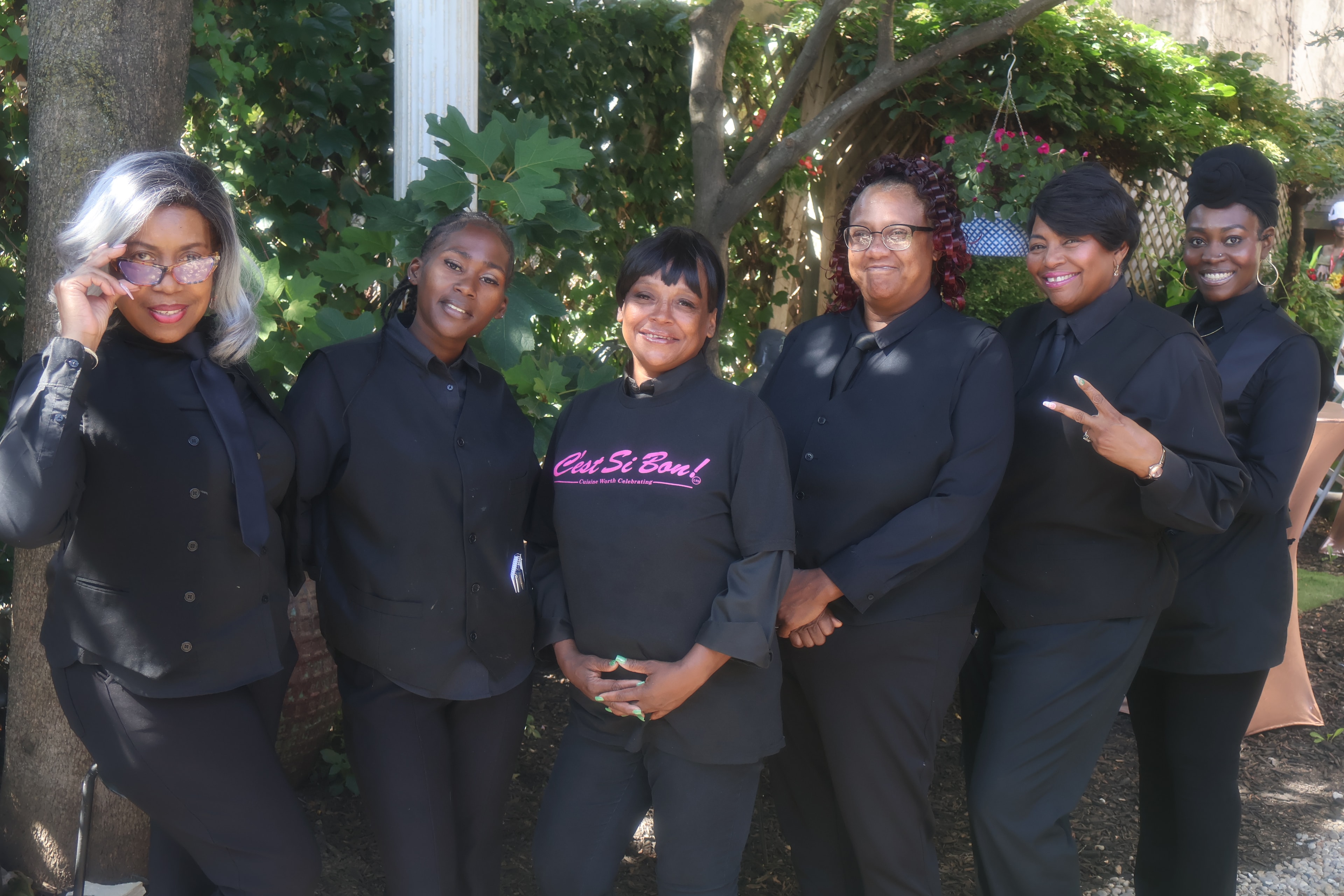 C'est Si Bon team of six women in black uniforms