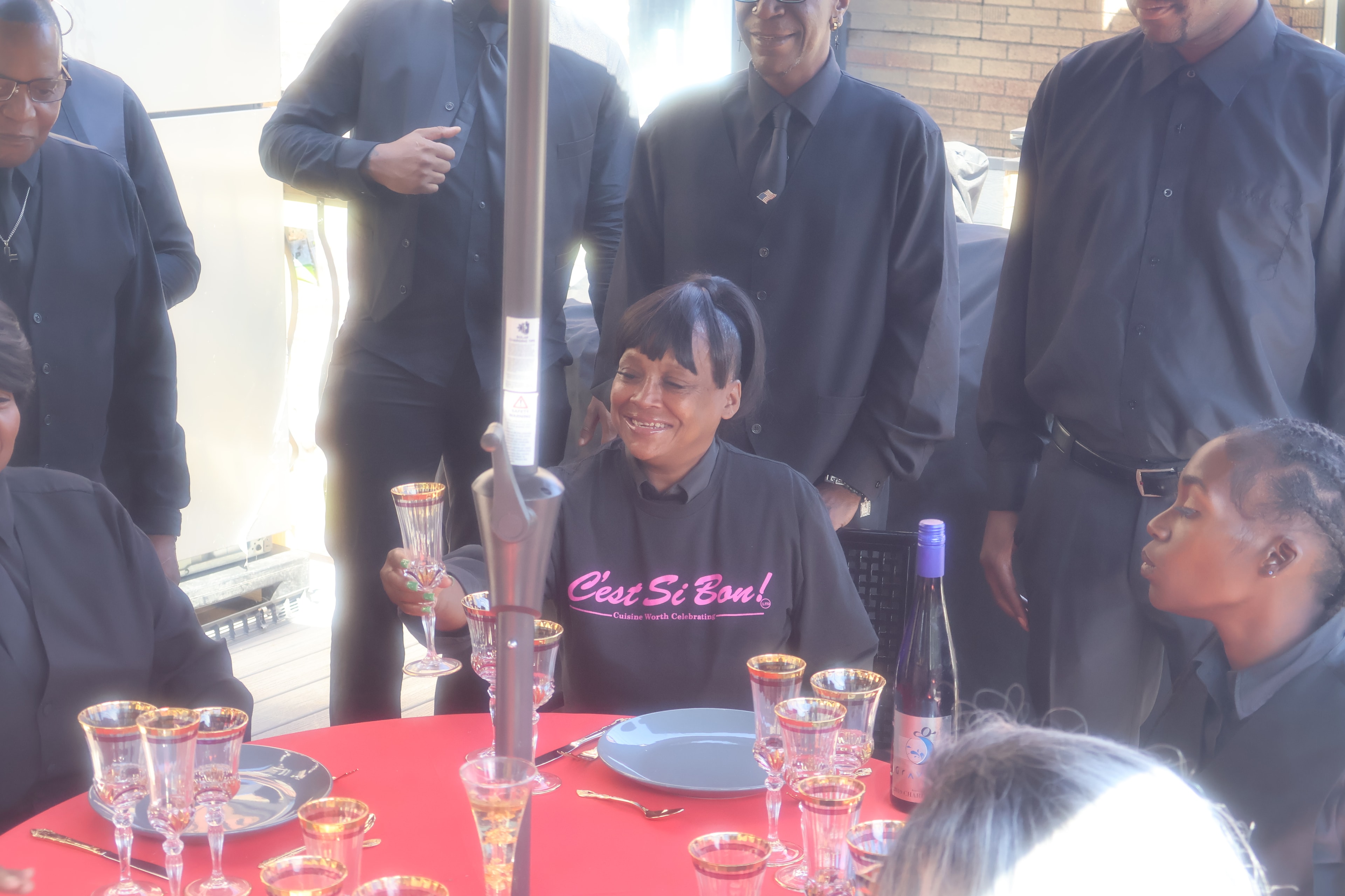 C'est Si Bon staff member smiling at table setting