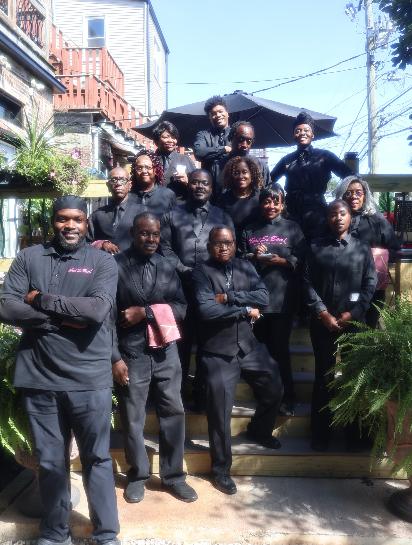 C'est Si Bon full team in black uniforms at outdoor event