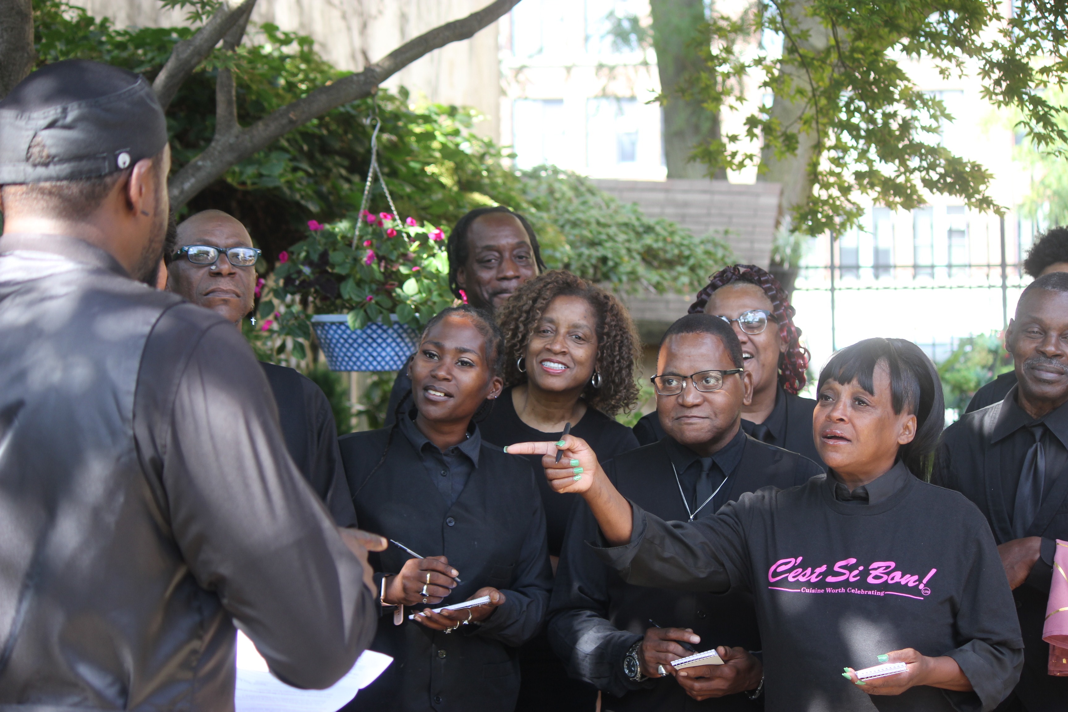 C'est Si Bon team receiving event briefing in garden