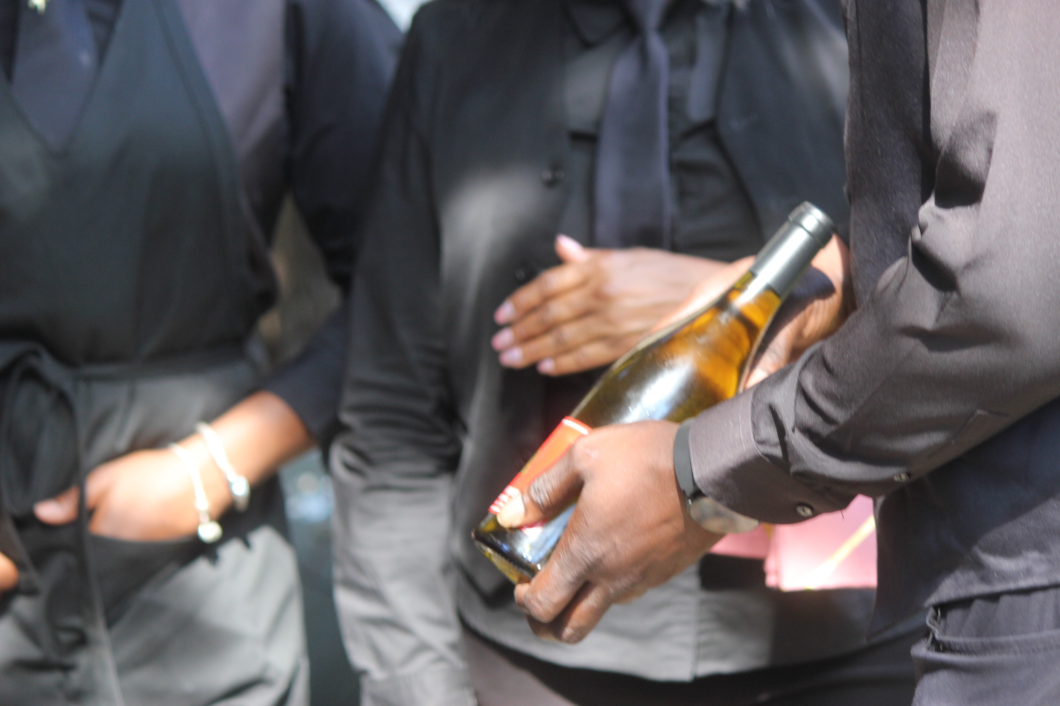 C'est Si Bon staff holding wine bottle at event