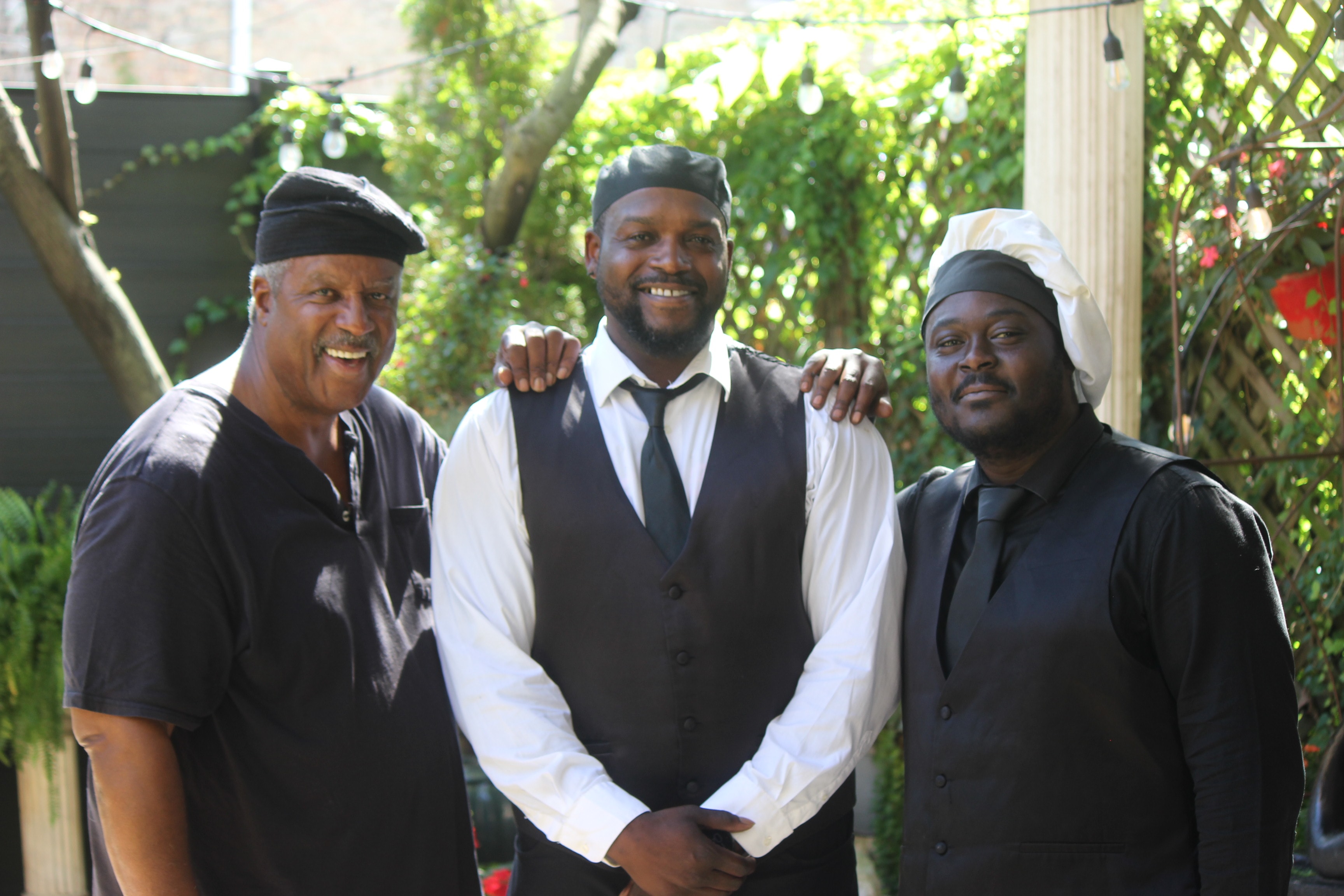 Three C'est Si Bon chefs and staff smiling in garden venue