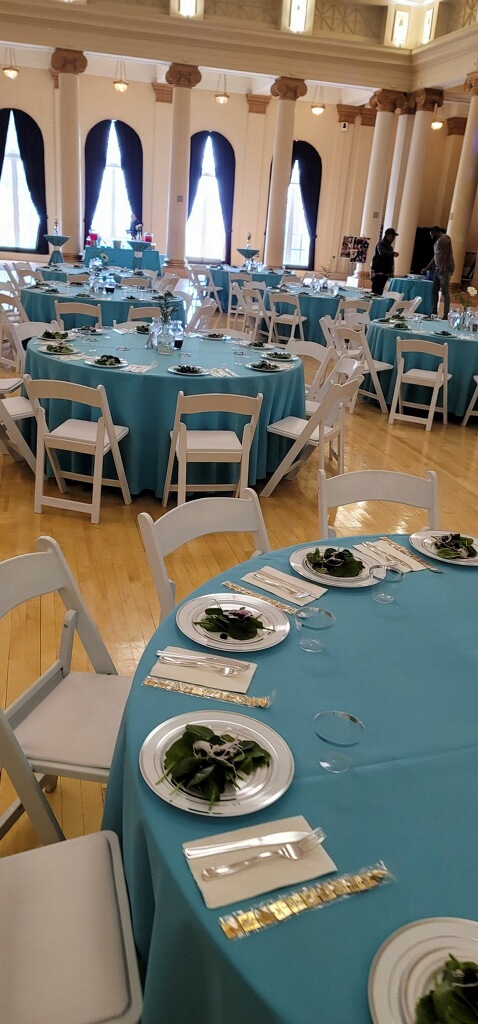 Elegant event venue with teal linens in a grand ballroom